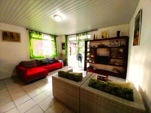 a living room with two couches and a red couch at TAHITI - Haumaru Beach Fare in Mahina