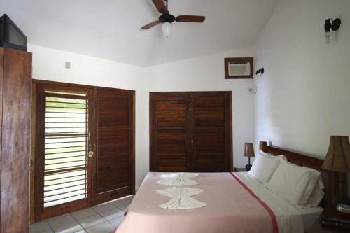 1 dormitorio con 1 cama y ventilador de techo en POUSADA CANTINHO MÁGICO, en Maraú