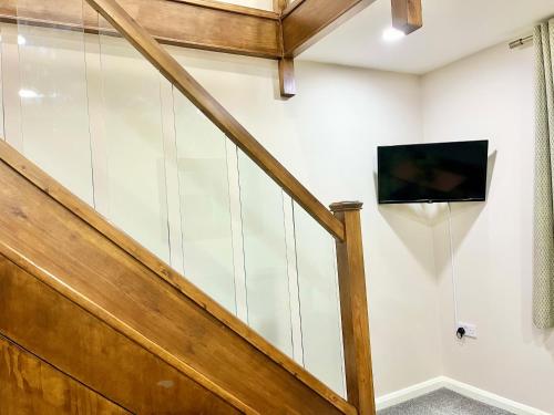 a room with a staircase with a tv on the wall at Ar-Rahman, 1 bed room and 1 Living room apartment in Kent