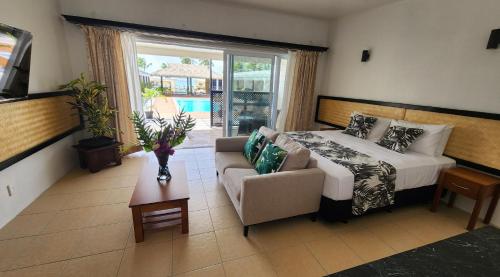 a bedroom with a bed and a couch and a table at Resort Tava'e in Amuri