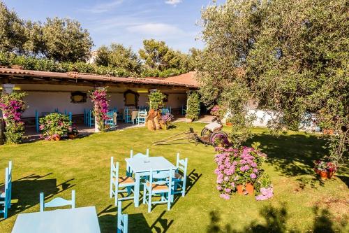 a yard with a table and chairs and flowers at hotel Piccolo Ranch in Pula