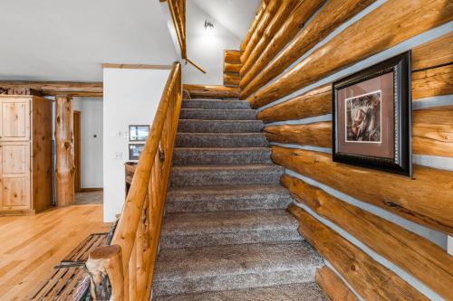 a staircase in a log home with a wooden wall at King's Cabin in West Yellowstone