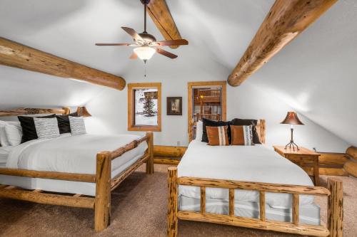 two beds in a room with wooden ceilings at King's Cabin in West Yellowstone