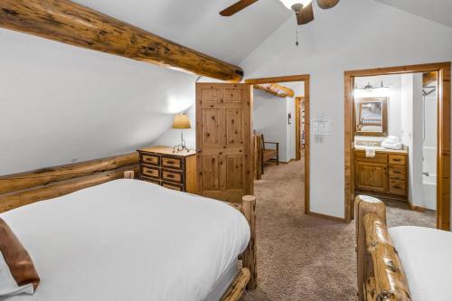 a bedroom with a white bed and a bathroom at King's Cabin in West Yellowstone
