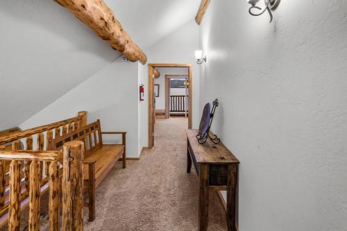 a hallway with a wooden bench and a stair case at King's Cabin in West Yellowstone