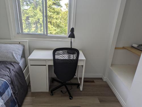 biurko z krzesłem obok łóżka i okno w obiekcie Home of Pleasantness w mieście Hamilton