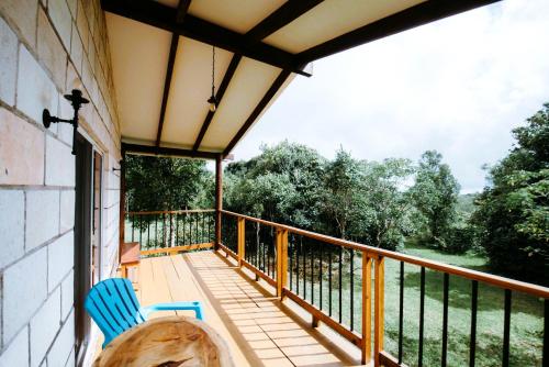 a porch with a blue chair on a balcony at Cabañas de la Montaña in Linaca