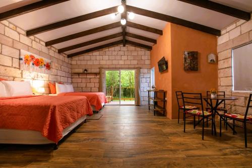 a bedroom with two beds and a table and chairs at Cabañas de la Montaña in Linaca