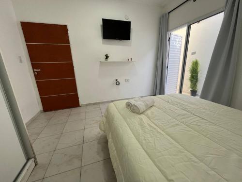 - une chambre avec un lit et une télévision murale dans l'établissement Ideal para 4 personas o familia, à Resistencia