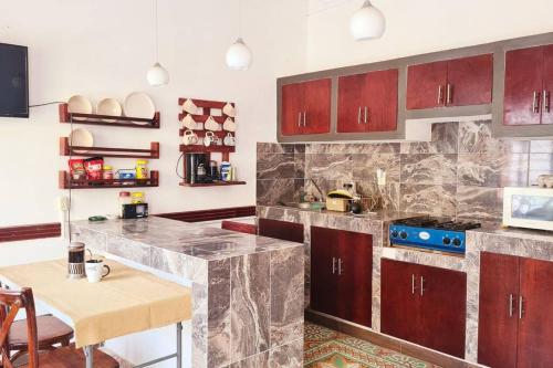 a kitchen with brown cabinets and a table and a counter top at Alojamiento completo en el centro in Veracruz