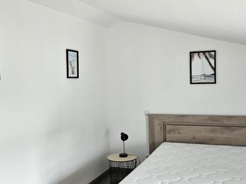 een slaapkamer met een bed en twee foto's aan de muur bij Gîte Les Magnils-Reigniers, 4 pièces, 6 personnes - FR-1-426-534 in Les Magnils-Reigniers