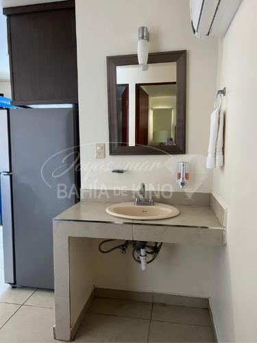 a bathroom with a sink and a mirror and a refrigerator at Esmeralda Joyas Del Mar Bahia de Kino in Bahía Kino
