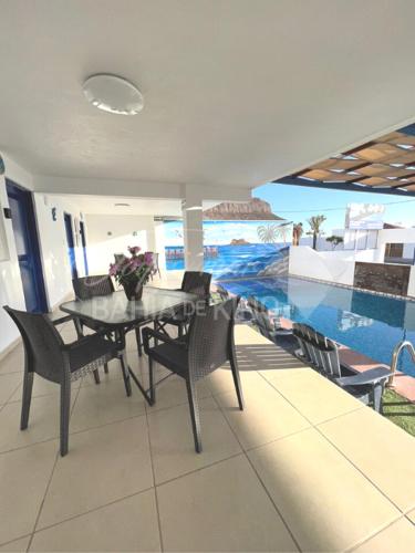 a dining room with a table and chairs and a pool at Esmeralda Joyas Del Mar Bahia de Kino in Bahía Kino