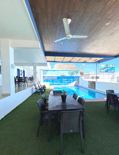 a dining room with a table and a swimming pool at Esmeralda Joyas Del Mar Bahia de Kino in Bahía Kino