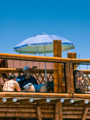 a group of people sitting on a boat with an umbrella at Hosteria La Medusa in Cocorná