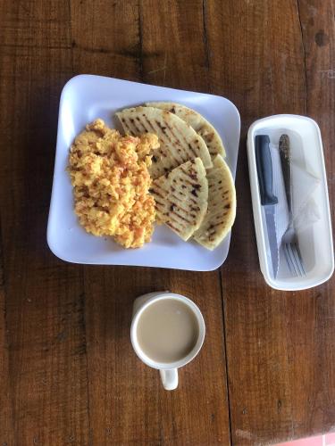een bord met eten, brood en een glas melk bij Villas del bambú in San Gil