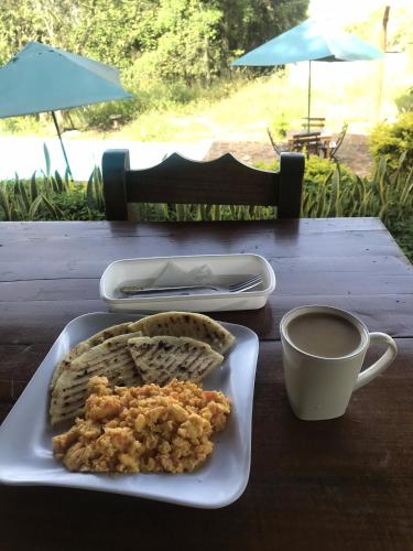 een bord eten op een tafel met een kopje koffie bij Villas del bambú in San Gil