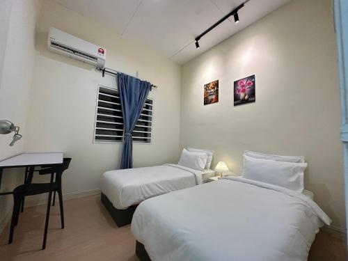 a bedroom with two beds and a desk and a window at 22A HOSTEL in George Town