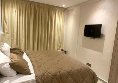 a bedroom with a bed with a television on the wall at CHIC & COSY appartement trés calme in Agadir