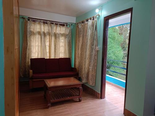 un soggiorno con divano e finestra di Hotel PineWood Tawang a Tawang