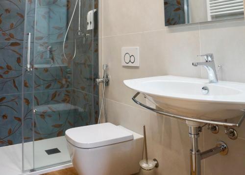 a bathroom with a sink and a toilet and a shower at Domus 44 Rooms - Porta Nuova in Verona