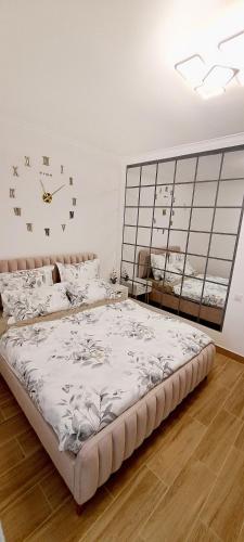 1 dormitorio con 1 cama grande y reloj en la pared en CozyStudio10, en Roşu