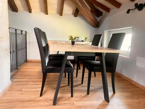 a dining room with a wooden table and black chairs at Domus 44 Apartments in Verona