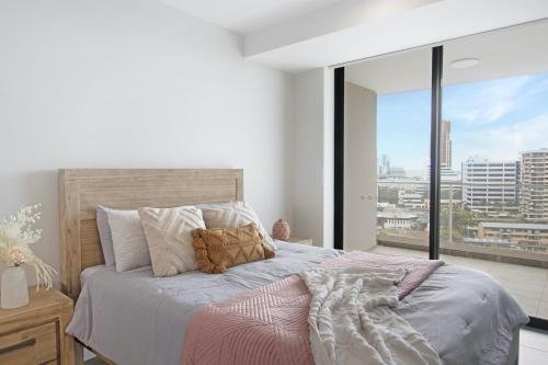 a bedroom with a bed with a view of a city at Luxury La Isla in Gold Coast