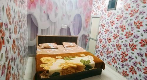 sypialnia z łóżkiem i wzorzystą ścianą kwiatową w obiekcie Super OYO Blossom Inn w mieście Patiala