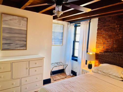 Schlafzimmer mit einem Bett und einem Deckenventilator in der Unterkunft Host your group - West End Sea Captain Home in Portland