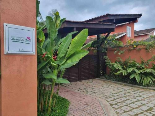 a sign on the side of a house with plants at Esplendor House - Little Cambury in São Sebastião