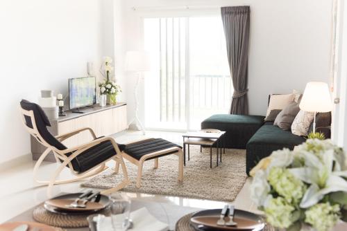 a living room with a green couch and a table at Zada Residence in Nakhon Ratchasima