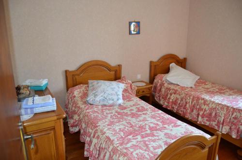 a small room with two beds and a night stand at Chambres D'hotes & Champagne Douard in La Chapelle-Monthodon
