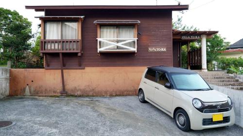 une camionnette blanche garée devant une maison dans l'établissement Villa Tora, à Onna