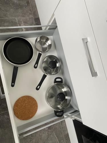 a kitchen with three pots and pans in a cabinet at Nisay Home - 3 Room Apartment - A1 in Ludwigsburg