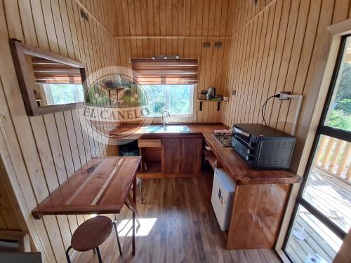 a kitchen with a sink and a table in a cabin at Cabaña El Canelo in Puerto Varas