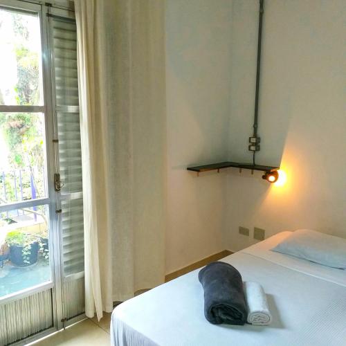 a bedroom with a bed and a large window at Micasa Hostel - Congonhas in Sao Paulo