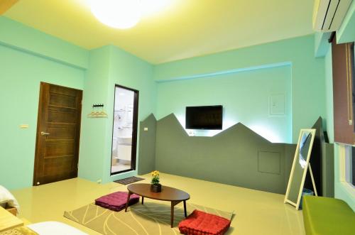a living room with blue walls and a table and chairs at 艾希兒民宿 I'm Here hostel l小家庭包棟首選l 台東包棟 l台東火車站l背包單人 in Taitung City