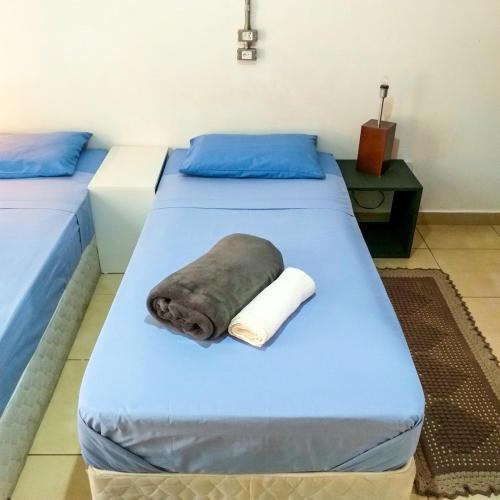 two beds in a room with a towel on them at Micasa Hostel - Congonhas in Sao Paulo