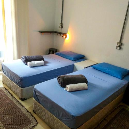 two beds in a room with blue sheets at Micasa Hostel - Congonhas in Sao Paulo