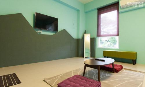 a room with a table and a chair and a television at 艾希兒民宿 I'm Here hostel l小家庭包棟首選l 台東包棟 l台東火車站l背包單人 in Taitung City