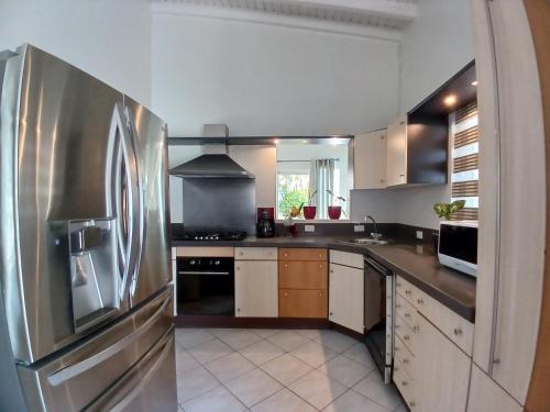 a large kitchen with a stainless steel refrigerator at Private Luxury Villa Palm Beach in Palm-Eagle Beach