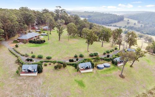 an aerial view of a house in a field with trees at Scarlet Woods Chalets in Quinninup