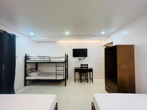 a bedroom with two bunk beds and a desk at Samba Bluewater Resort in Olongapo