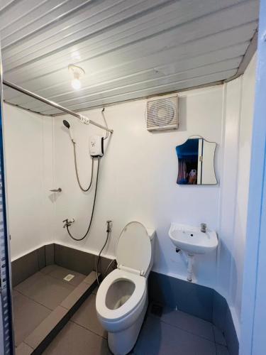 a bathroom with a toilet and a sink at Samba Bluewater Resort in Olongapo