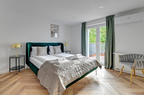 a bedroom with a large bed and a balcony at Lion Apartments - Comfy Sopot Family House in Sopot