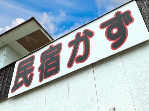 a sign on the side of a building at 民宿かず in Sosa