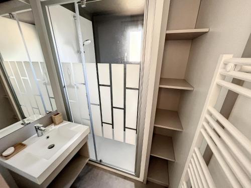 une salle de bain avec un lavabo et un miroir dans l'établissement Chalet de standing pour 4 pers., piscine couverte et chauffée, à deux pas de la plage, Wi-Fi gratuit - FR-1-361-515, à Jullouville