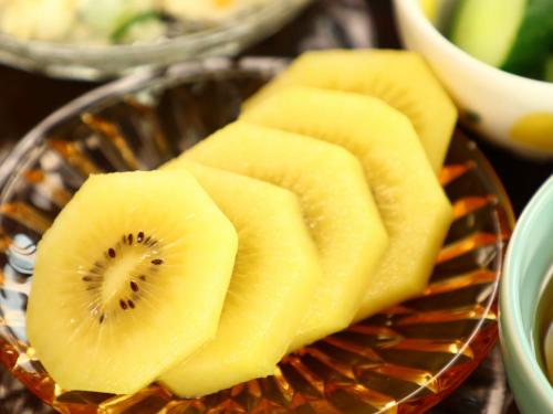 a glass plate with sliced kiwi slices on it at 民宿かず in Sosa