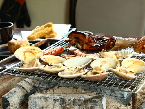 a tray of food on a grill with meat and other foods at 民宿かず in Sosa